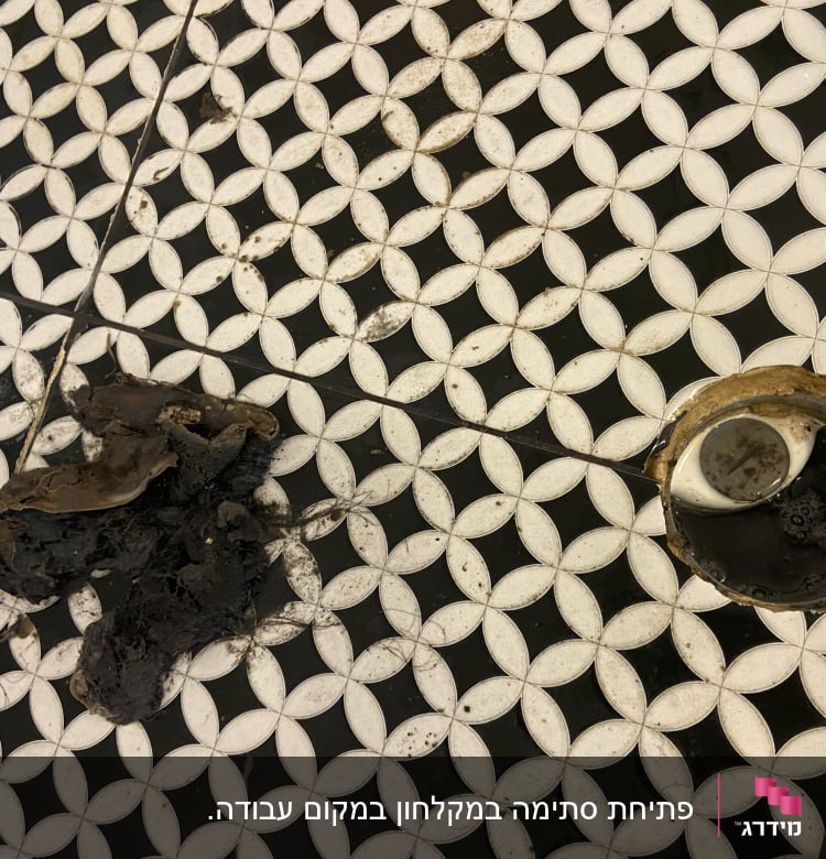 פתח ניקוז פתוח עם לכלוך על הרצפה